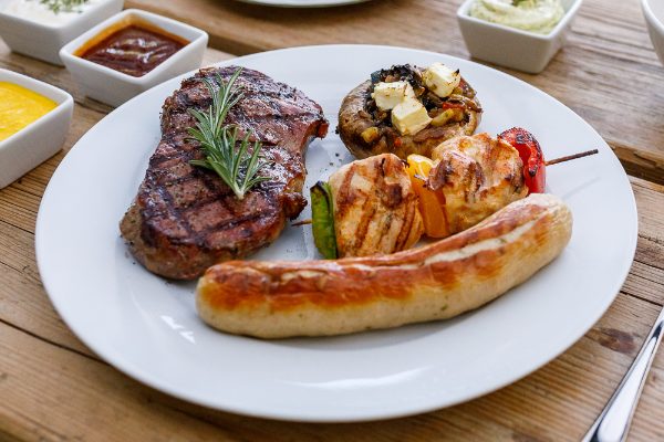Grillteller mit Steak, Bratwurst, Hähnchenspieß und Dips