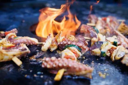 Spieße auf der heißen Grillplatte mit offener Flamme