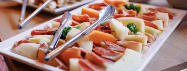 Melone mit rohem Schinken auf dem Vorspeisenbuffet
